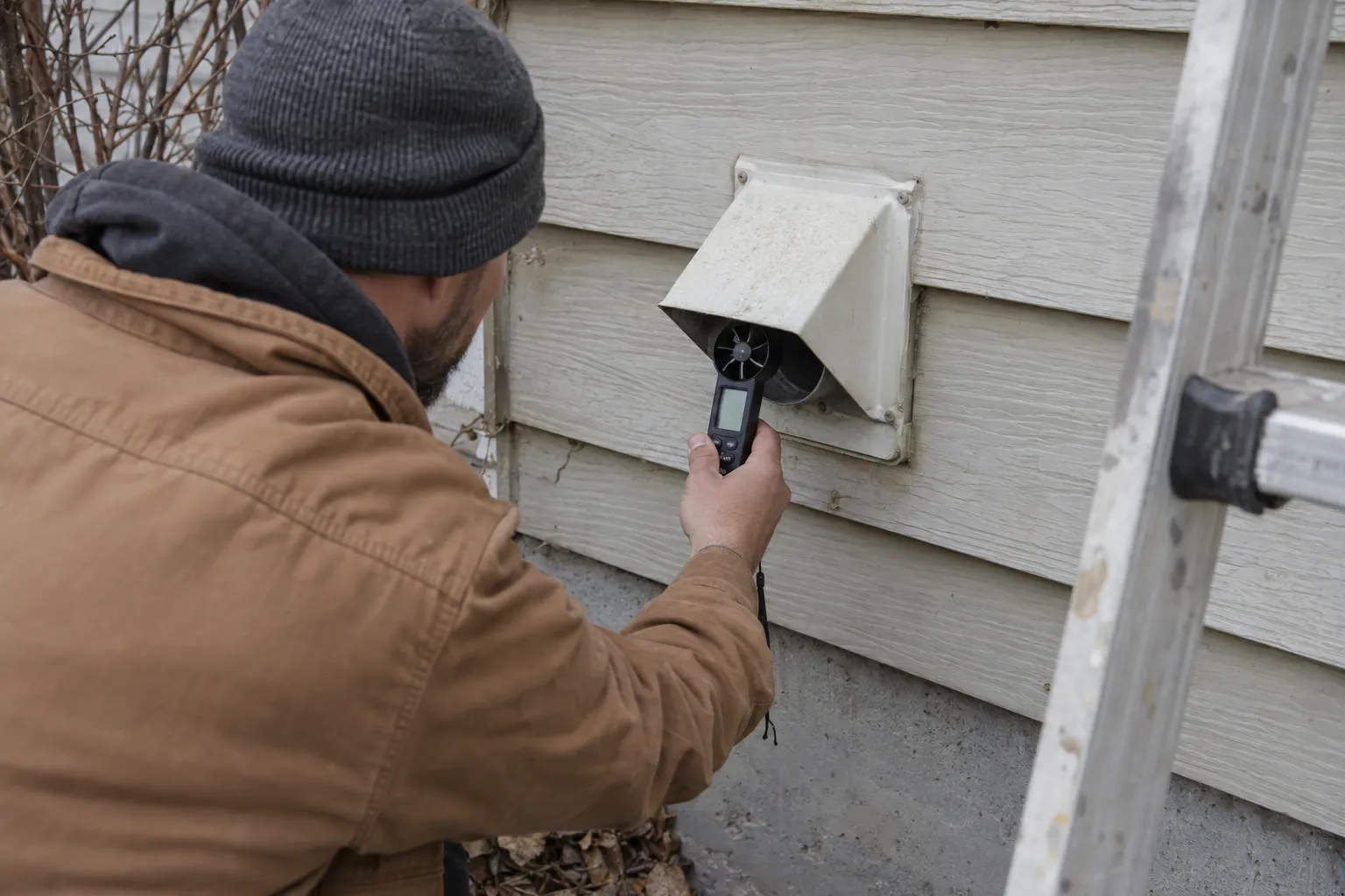 Technician checking airflow at the exterior dryer vent